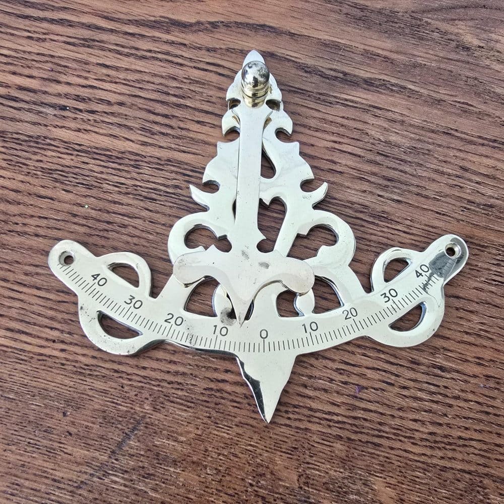 Inclinomètre ancien en laiton vu de face sur table en bois