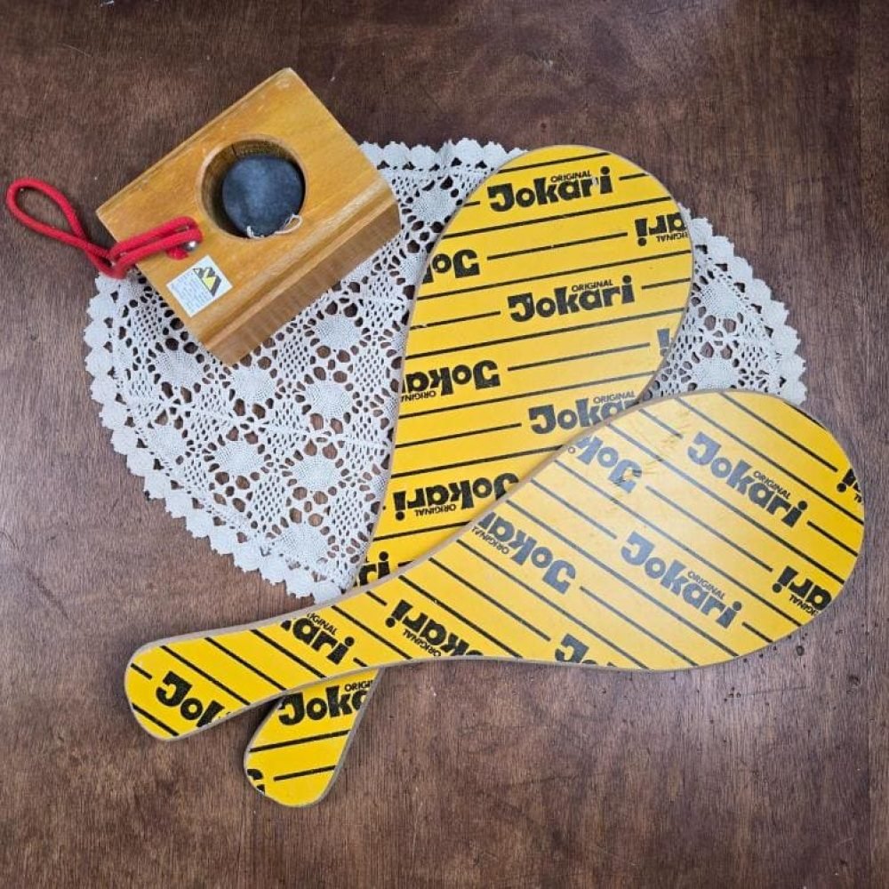 Raquettes de Jokari vintage jaunes avec cordon élastique et balle sur support en bois