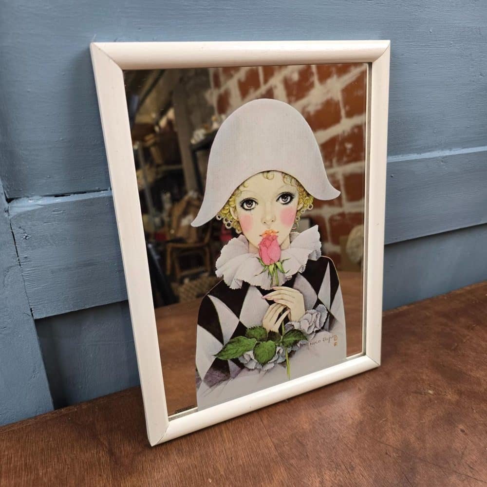 Vue de côté du miroir Arlequin, reflets sur le verre et détails du visage.