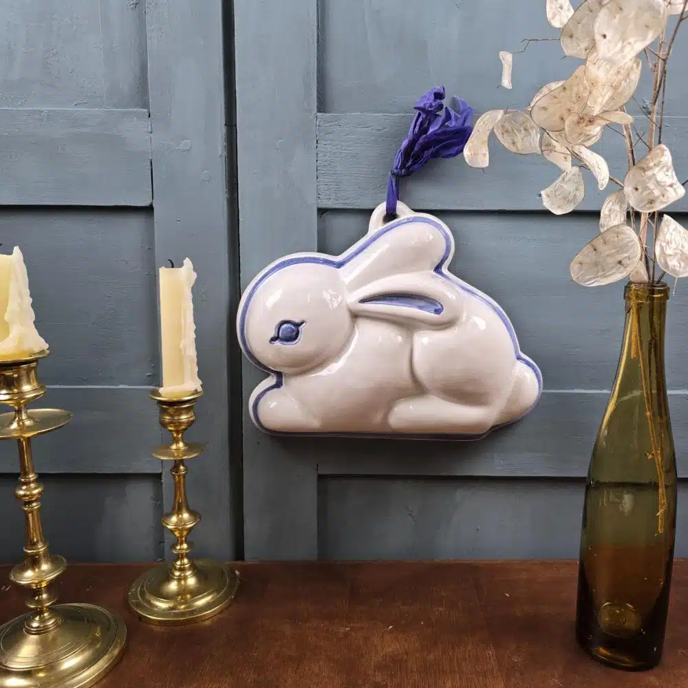 Moule vintage en céramique blanche et bleue en forme de lapin suspendu au mur, signé Thun Italy.