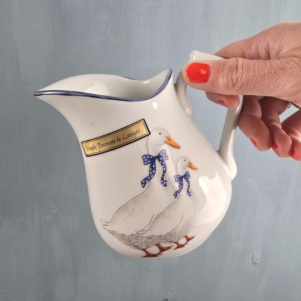 Pichet Limoges décor oies en mouvement, tenu en main