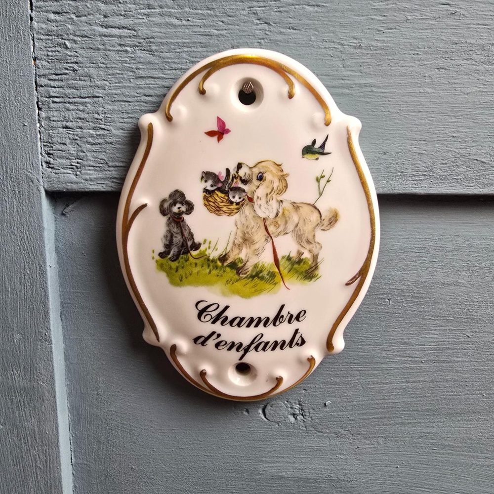 Vue rapprochée de la plaque « Chambre d’enfants » accrochée sur un panneau bleu