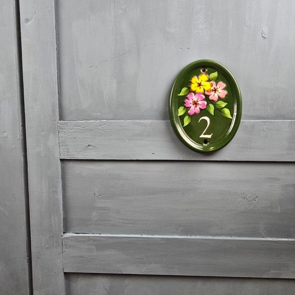 Vue de face de la plaque de porte N°2 signée Mike sur fond gris.