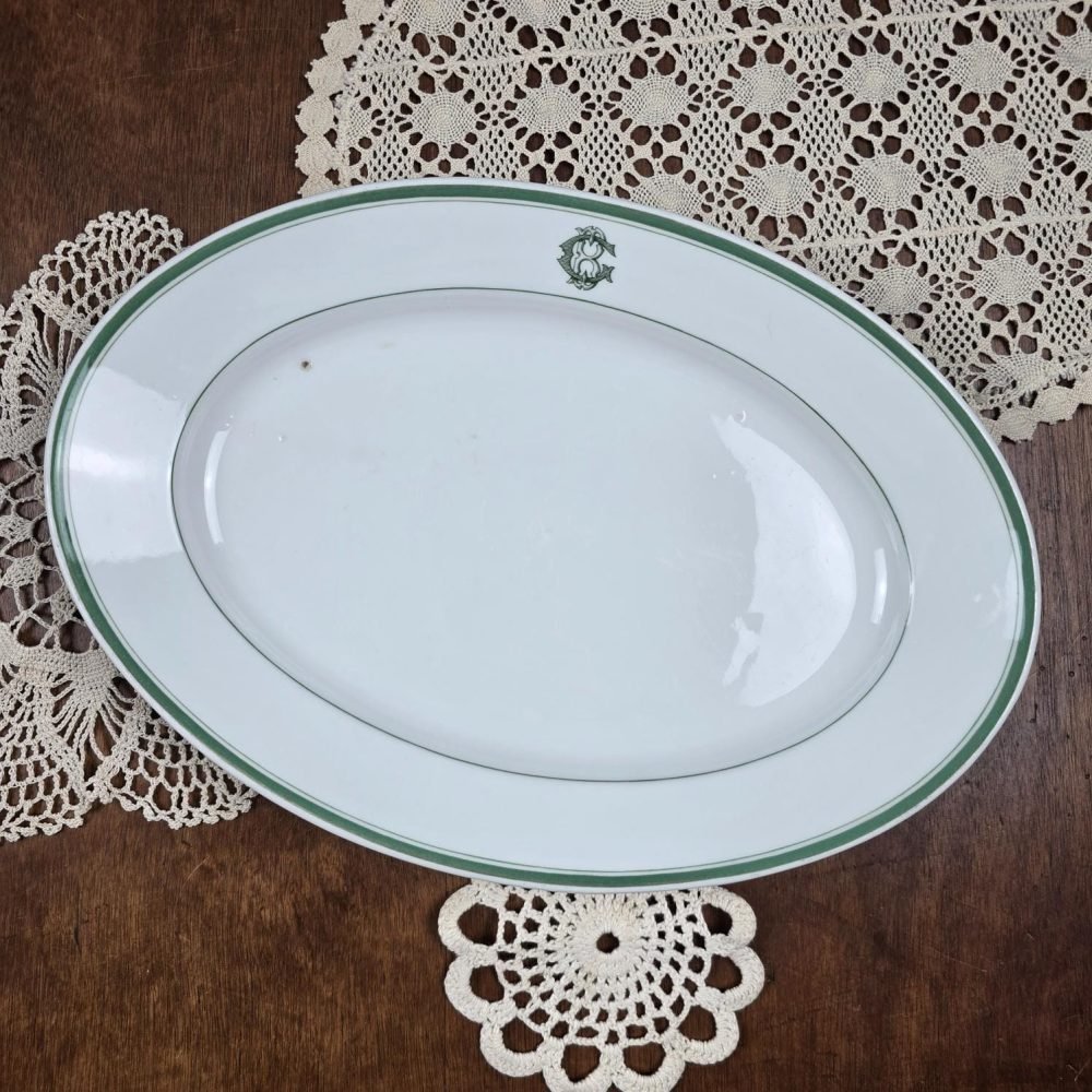 Plat ovale ancien Mehun France – Porcelaine blanche liseré vert sur table en bois et napperons
