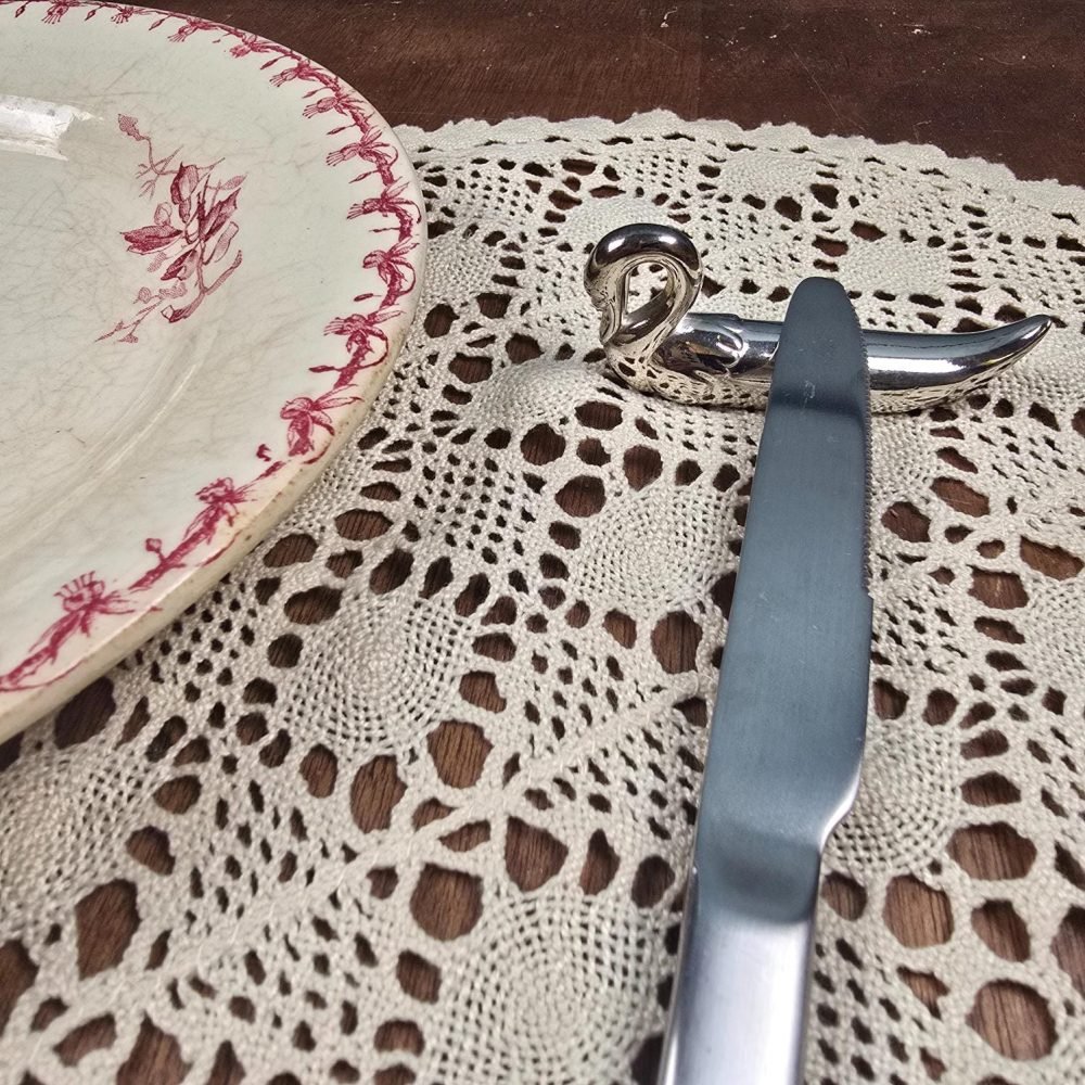 Repose-couteaux forme cygne en métal argenté vintage, avec couteau vue de trois quart