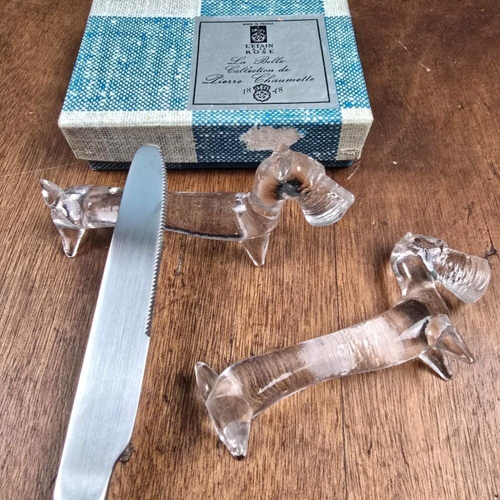 Repose-couteau Scottie en verre utilisé sur une table avec un couteau vintage.