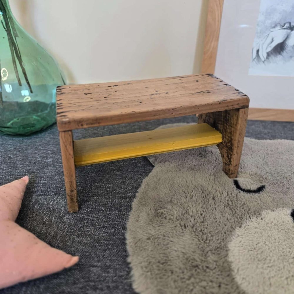 Petit tabouret ancien artisanal en bois rénové avec traverse jaune moutarde dans une ambiance enfantine