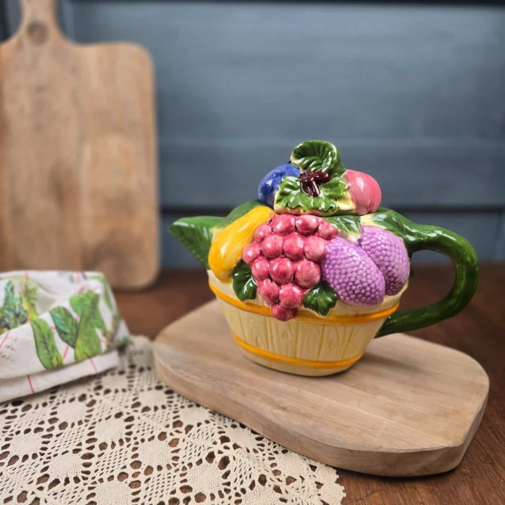 Théière vintage corbeille de fruits style barbotine – Céramique fruits en relief ambiance vintage, fond flouté