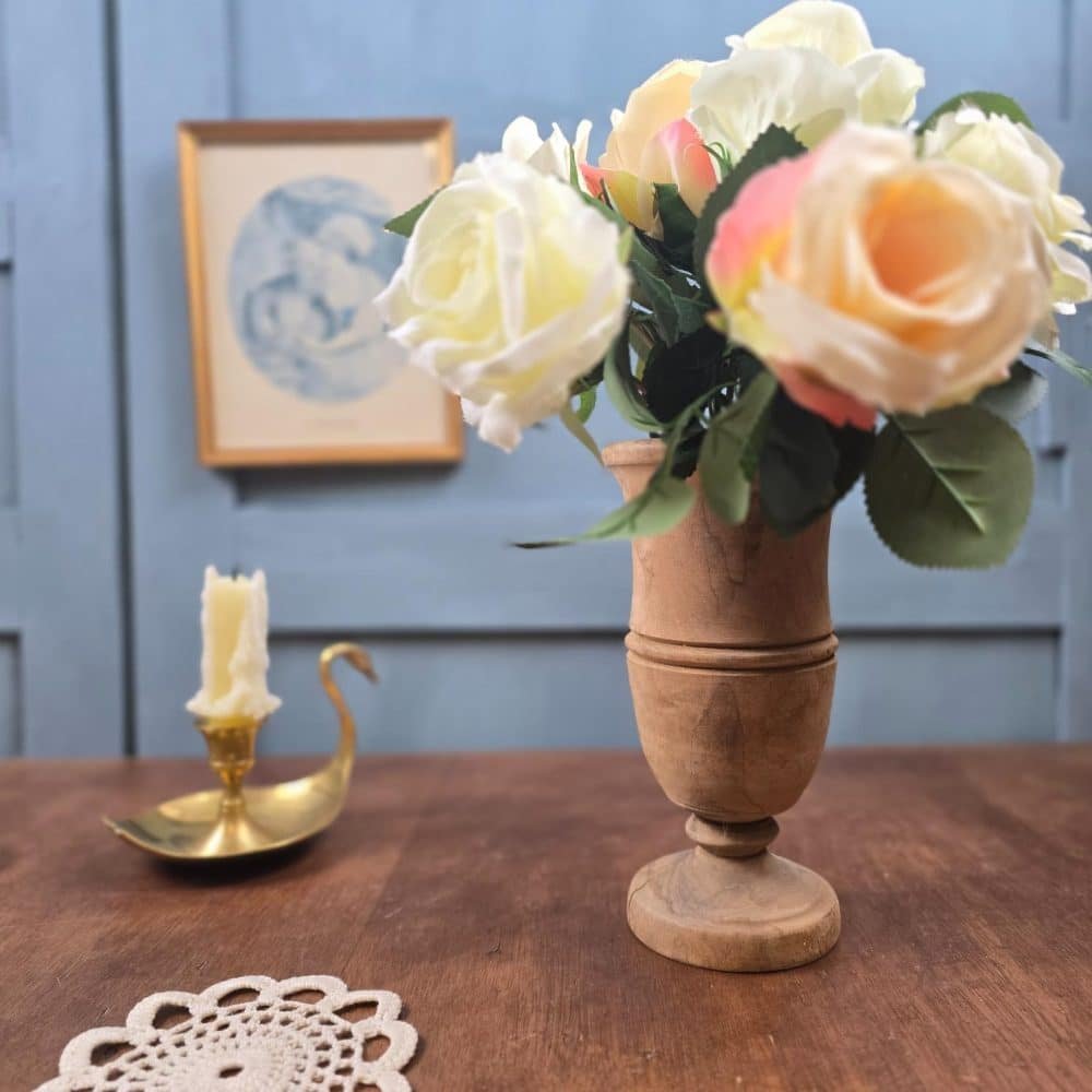 Vase en bois tourné utilisé comme soliflore avec un bouquet de fleurs, en situation déco.
